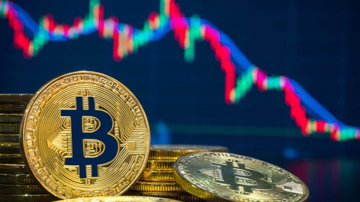 Bitcoin-Münzen vor einem fallenden Kurschart