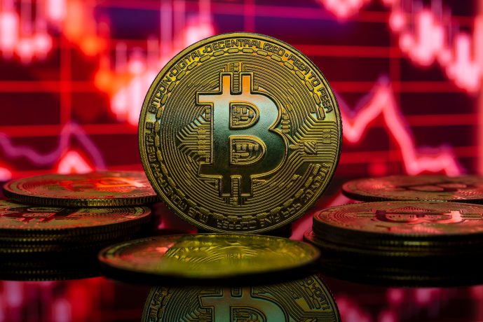 Eine Bitcoin-Münze vor rotem Hintergrund