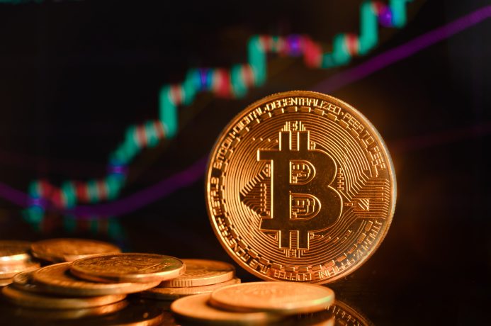 Bitcoin-Münzen for einem steigenden Candlestick-Chart
