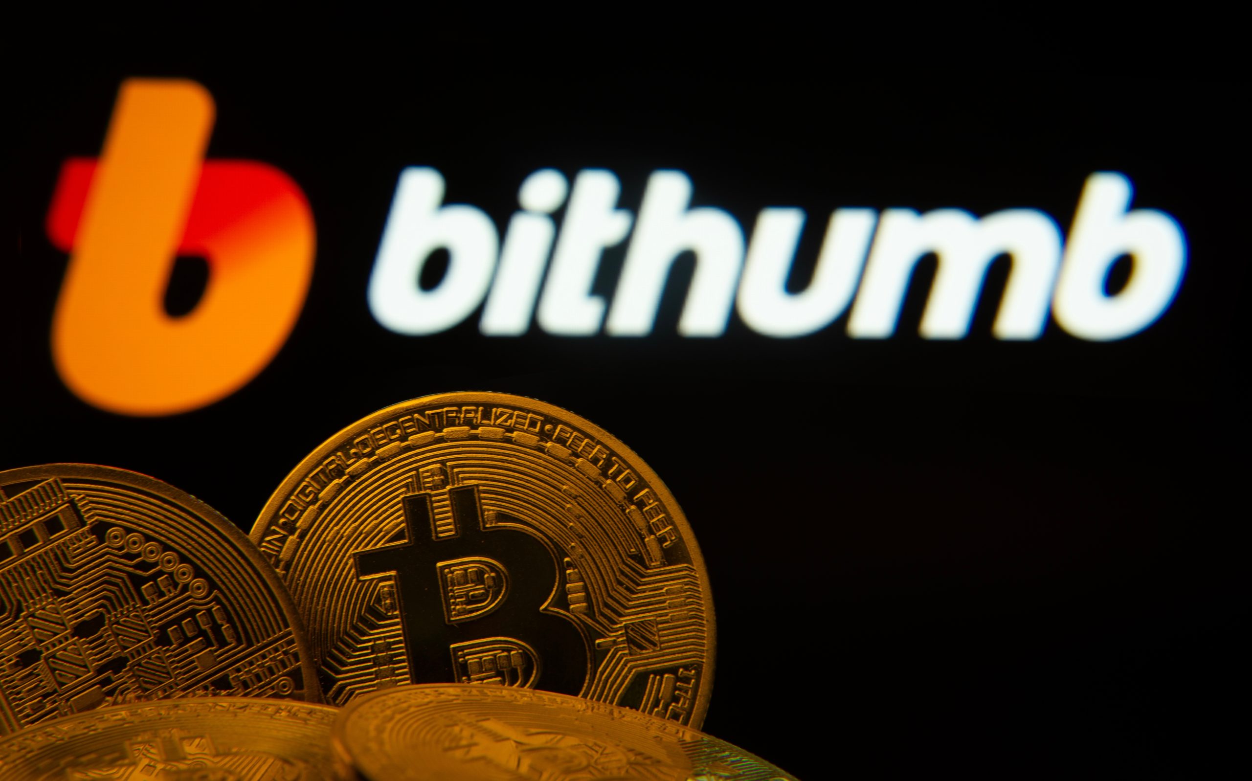 Bitcoin-Münzen vor Bithumb-Logo