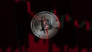 Bitcoin-Münze vor einem roten Kurschart mit fallenden Kerzen