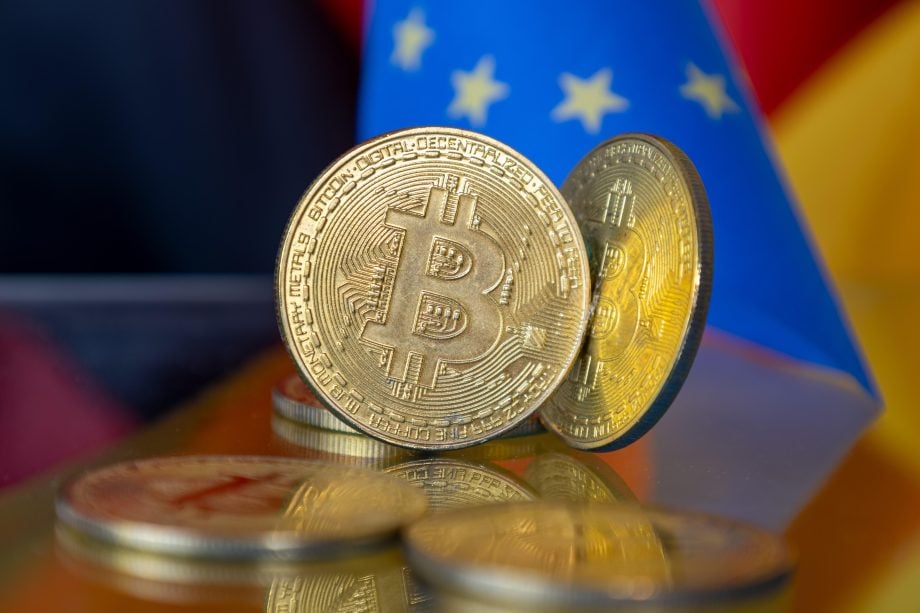 Nahaufnahme von symbolischen Bitcoins mit einer EU-Flagge