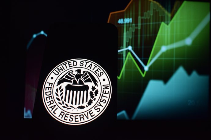 Siegel des Federal Reserve System auf einem Smartphone vor Kurscharts