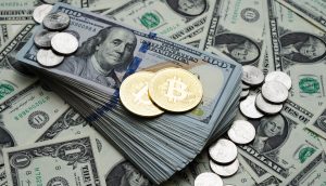 Das Bild zeigt eine goldene Bitcoin-Münze sowie US-Dollar