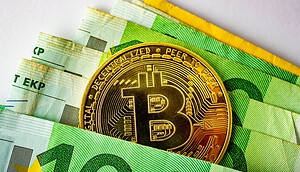 Bitcoin-Münze zwischen Euro-Banknoten