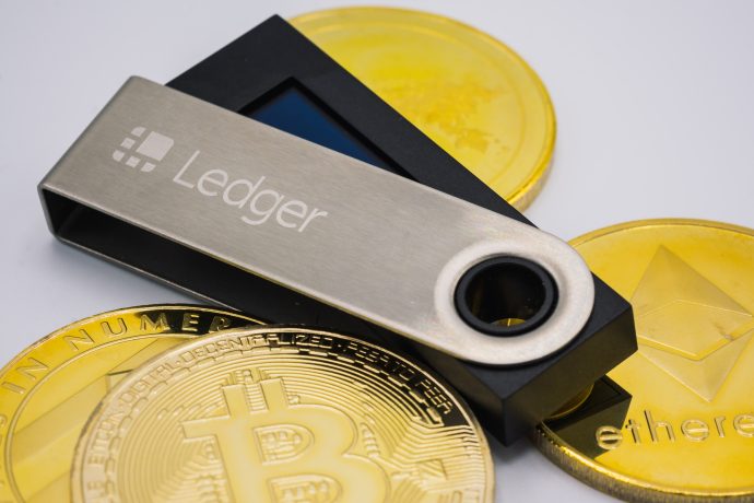 Eine Ledger-Wallet liegt auf Krypto-Münzen