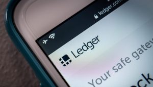 Das Bild zeigt das Ledger-Logo auf einem Smartphone-Bildschirm