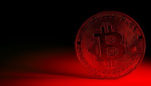 Bitcoin-Münze vor rotem Hintergrund