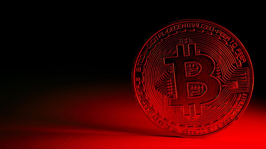 Bitcoin-Münze vor rotem Hintergrund