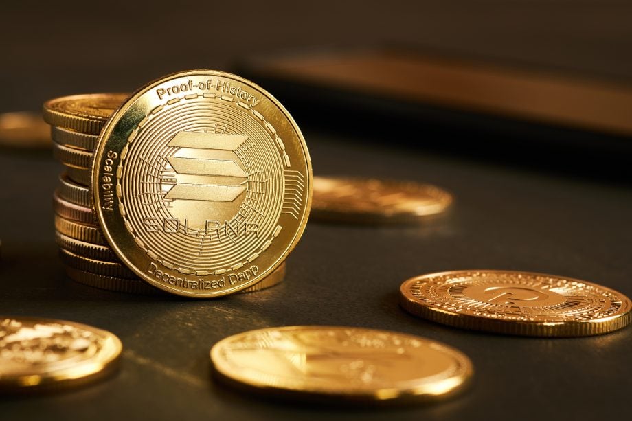 Ein Stapel goldfarbener Solana-Kryptowährungsmünzen auf einer dunklen Fläche.