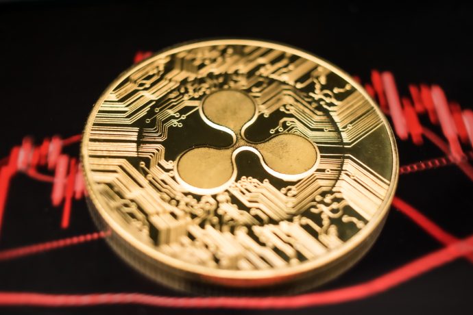 Eine XRP-Münze vor einem roten Chart
