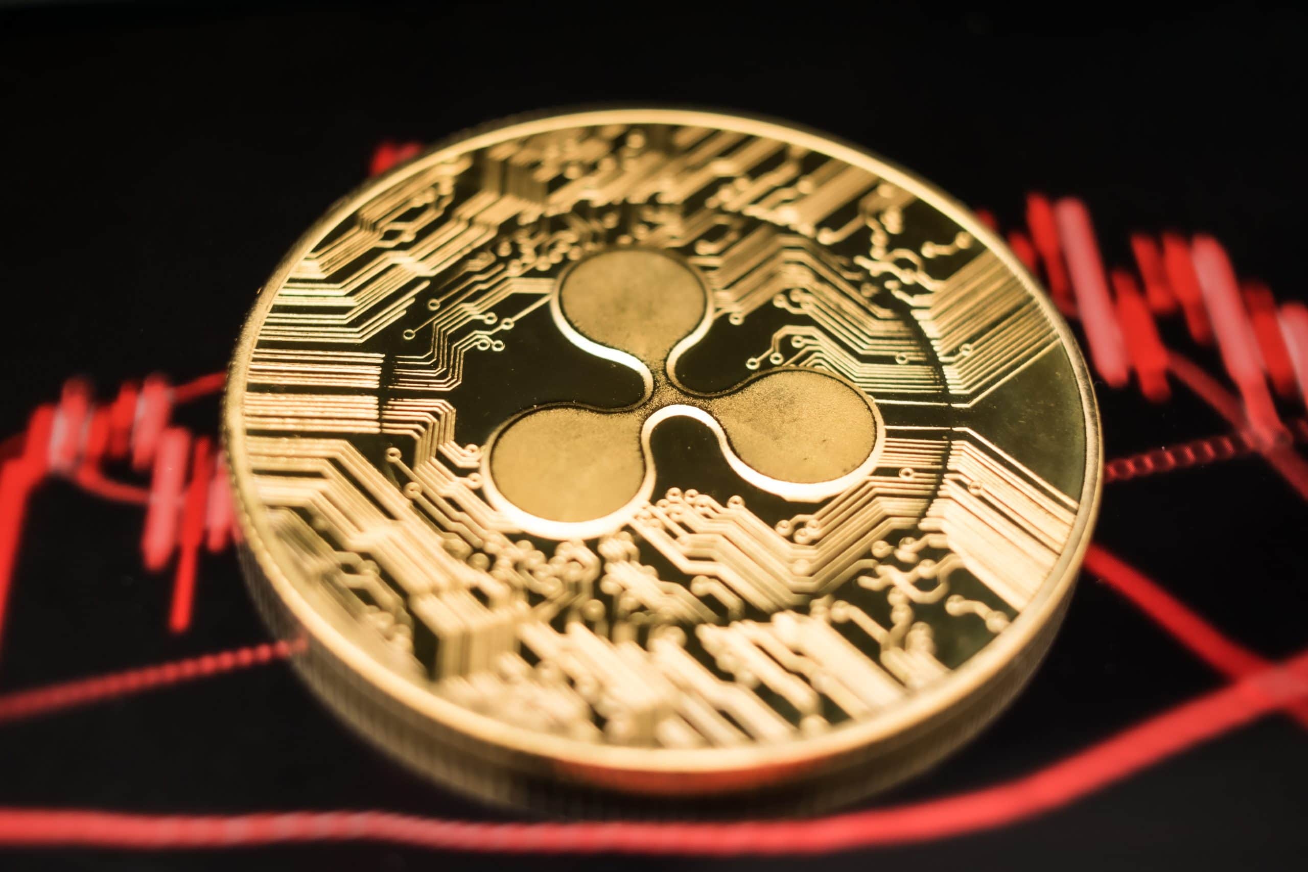 Eine XRP-Münze vor einem roten Chart